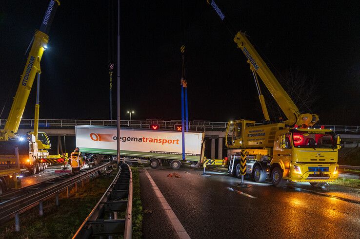 In beeld: Vrachtwagen schaart op A28 en knalt door vangrail, chauffeur gewond - Foto: Peter Denekamp