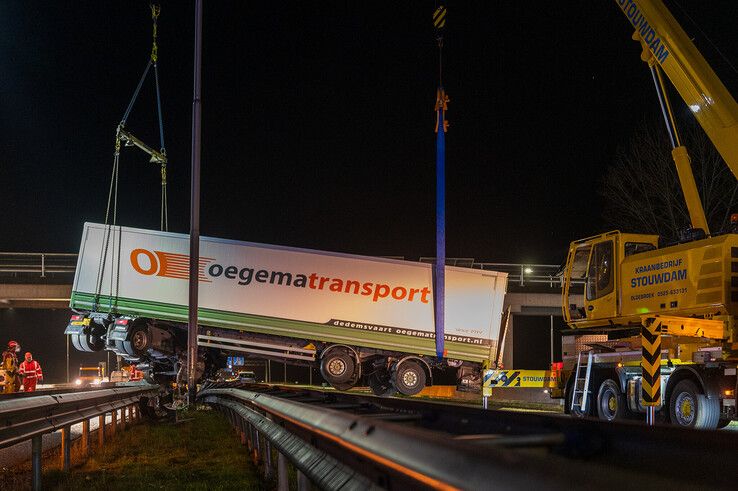 In beeld: Vrachtwagen schaart op A28 en knalt door vangrail, chauffeur gewond - Foto: Peter Denekamp