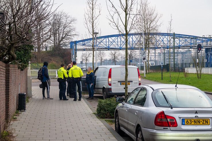 Politieagenten en boa's van NS op de Oosterlaan nabij de Van Karnebeekstraat. - Foto: Peter Denekamp