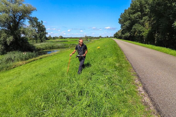 Een dijkbeheerder inspecteert de dijk.