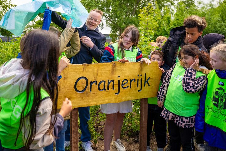 Kinderen en de wethouder onthullen het naambordje.