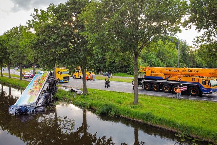 In beeld: Vrachtwagen raakt te water bij Nieuwleusen, chauffeur met spoed naar ziekenhuis