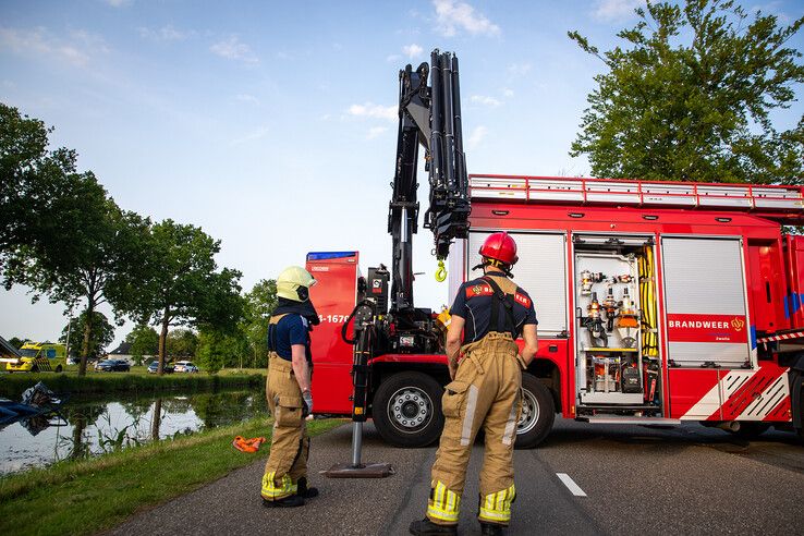 In beeld: Vrachtwagen raakt te water bij Nieuwleusen, chauffeur met spoed naar ziekenhuis