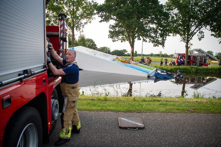 In beeld: Vrachtwagen raakt te water bij Nieuwleusen, chauffeur met spoed naar ziekenhuis
