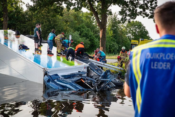 Hulpdiensten bij vrachtwagen in het kanaal naast N377 bij Nieuwleusen.
