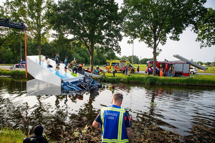 In beeld: Vrachtwagen raakt te water bij Nieuwleusen, chauffeur met spoed naar ziekenhuis