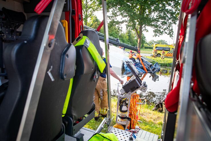 In beeld: Vrachtwagen raakt te water bij Nieuwleusen, chauffeur met spoed naar ziekenhuis