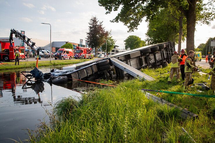 In beeld: Vrachtwagen raakt te water bij Nieuwleusen, chauffeur met spoed naar ziekenhuis