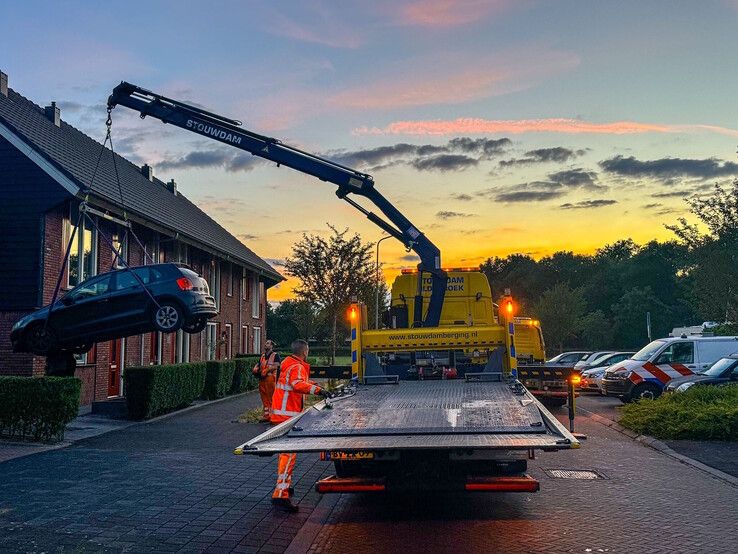 De auto wordt weggetakeld door een berger bij de woning in Heerde.