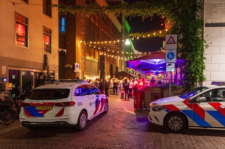 Politieagenten bij het slachtoffer op een terras in de Voorstraat.