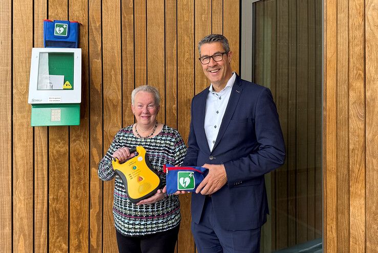 Van links af Annie van ’t Zand van EHBO Kampen en wethouder Jan Peter van der Sluis met een AED.