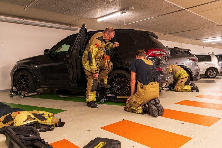 Brandweer haalt naar brand stinkende BMW X5 uit parkeergarage in Zwolle