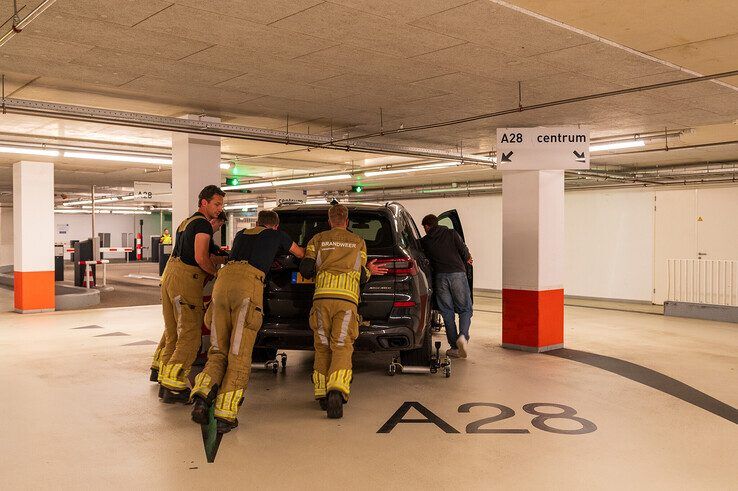 Brandweer haalt naar brand stinkende BMW X5 uit parkeergarage in Zwolle