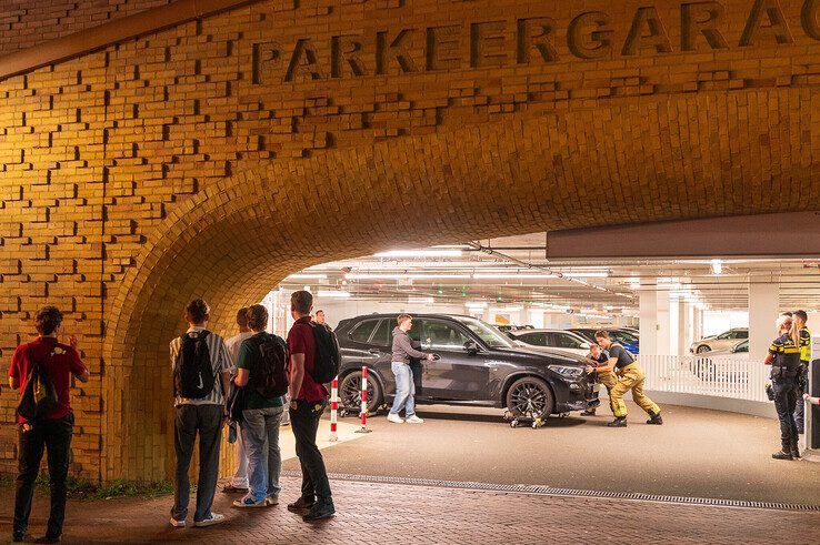 Brandweer haalt naar brand stinkende BMW X5 uit parkeergarage in Zwolle