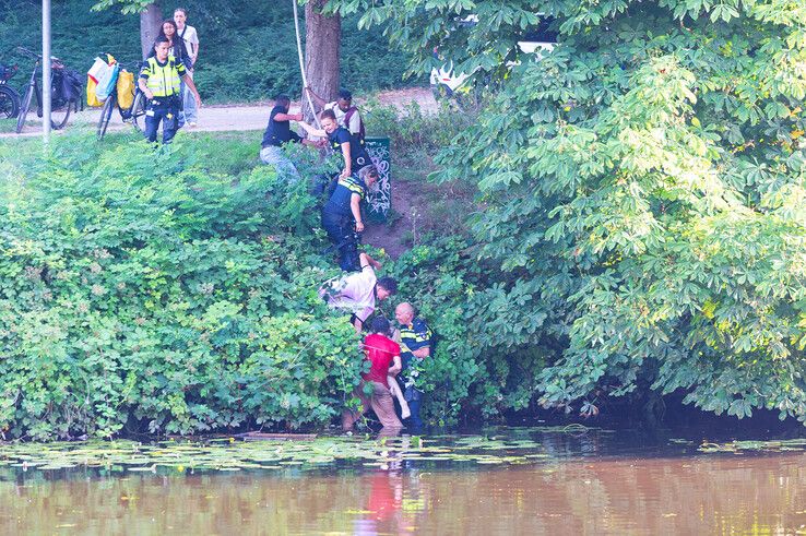 In beeld: Voorbijgangers en agenten redden man uit stadsgracht in Zwolle