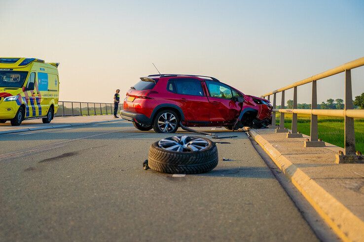 De flink beschadigde auto na botsing tegen brugreling in Kamperveen.