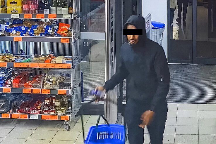 De overvaller kijkt bij het binnenkomen van de Aldi even vol in de camera.