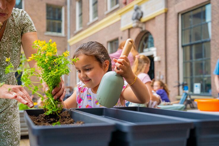 In beeld: Kinderen maken bibliotheekplein Kampen groener met hulp van de Groene Loper