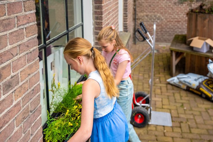 In beeld: Kinderen maken bibliotheekplein Kampen groener met hulp van de Groene Loper