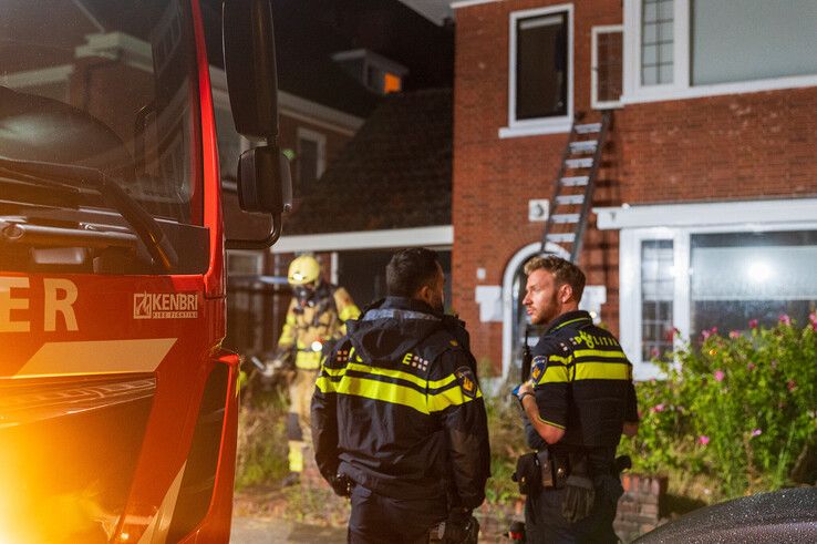 Een brandweerman brengt de drooggekookte pan naar buiten.