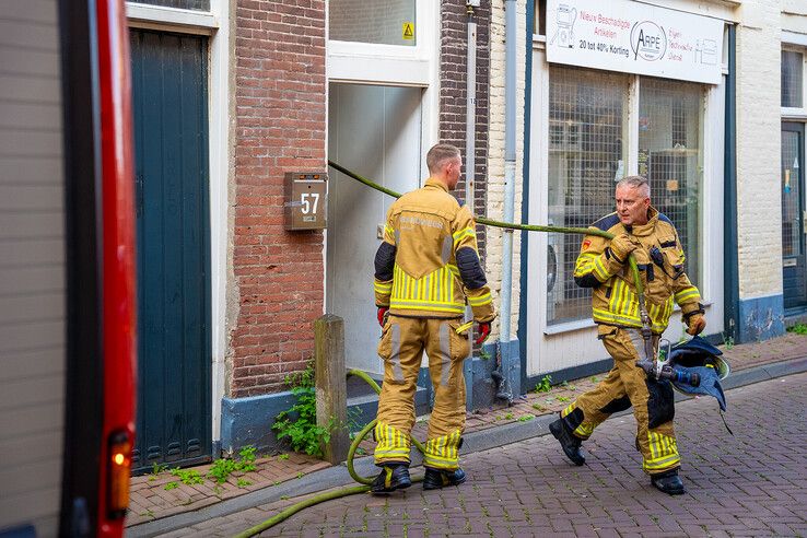 Brandweerlieden trokken de slang door de woning aan de Buiten Hofstraat in Kampen.