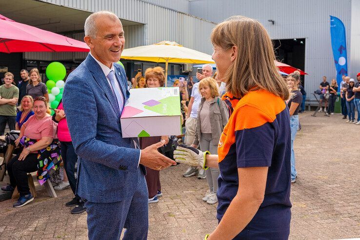 Wethouder Bas Wonink geeft laatste boekenpakket aan bezorgster PostNL.