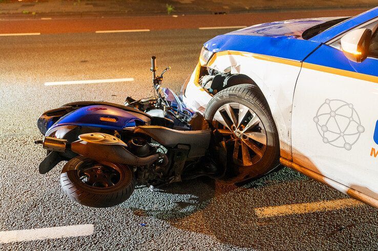 Scooterrijder gewond bij aanrijding in Zwolle, scooter klem onder auto