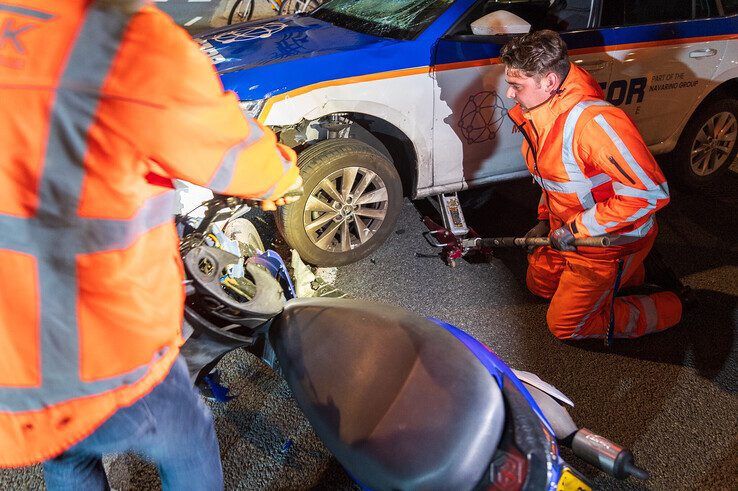 Scooterrijder gewond bij aanrijding in Zwolle, scooter klem onder auto