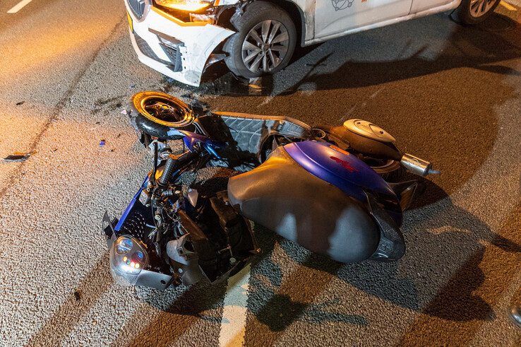 Scooterrijder gewond bij aanrijding in Zwolle, scooter klem onder auto
