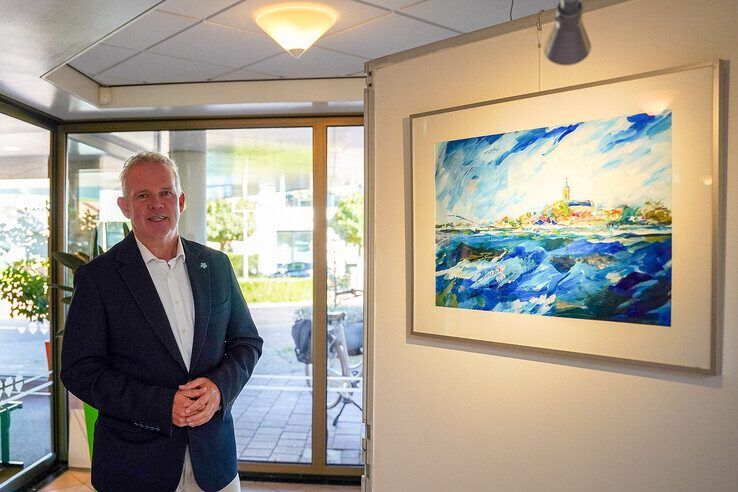Wethouder Jan van der Poel bij een schilderij van expositie HEK 40.