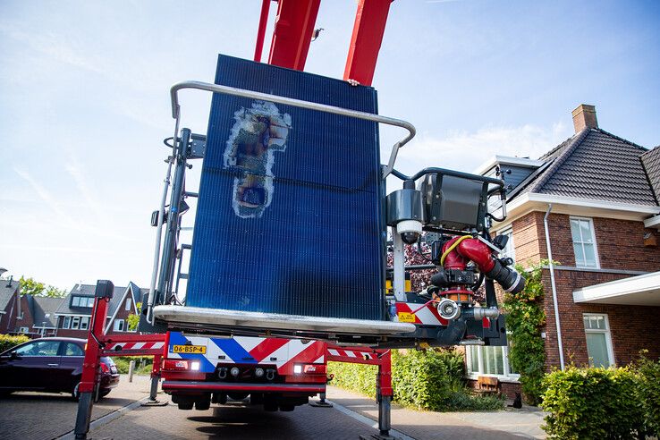 Brandweer verwijdert beschadigd zonnepaneel van dak woning in Zwolle.