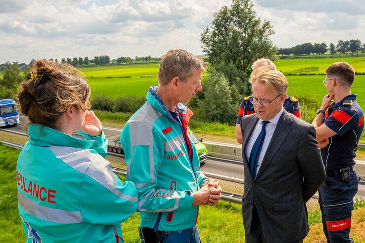 Minister in gesprek met hulpverleners bij  N50 in Kampen.