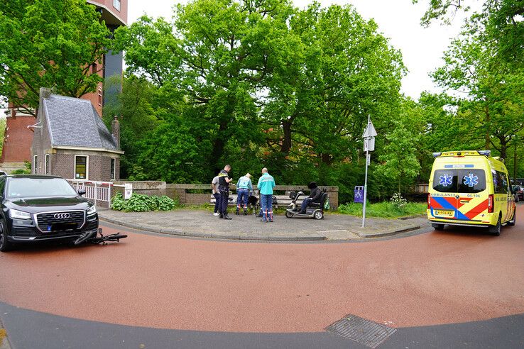 Jonge man onderuit op vouwfiets en onder auto terecht