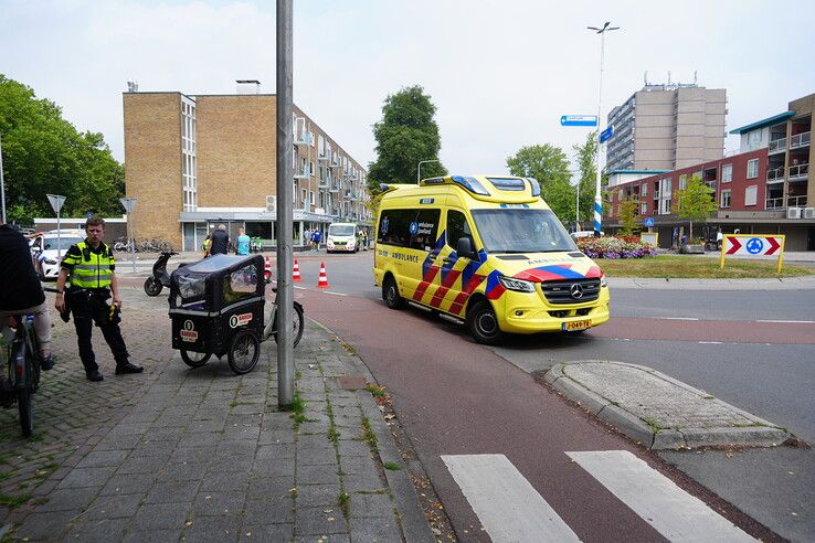 Vrouw met bakfiets kantelt op rotonde