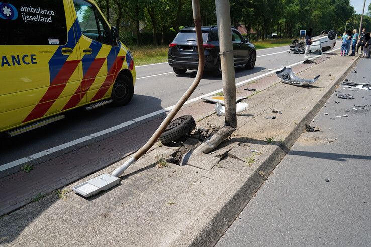 Auto slaat over de kop na botsing met lantaarnpaal