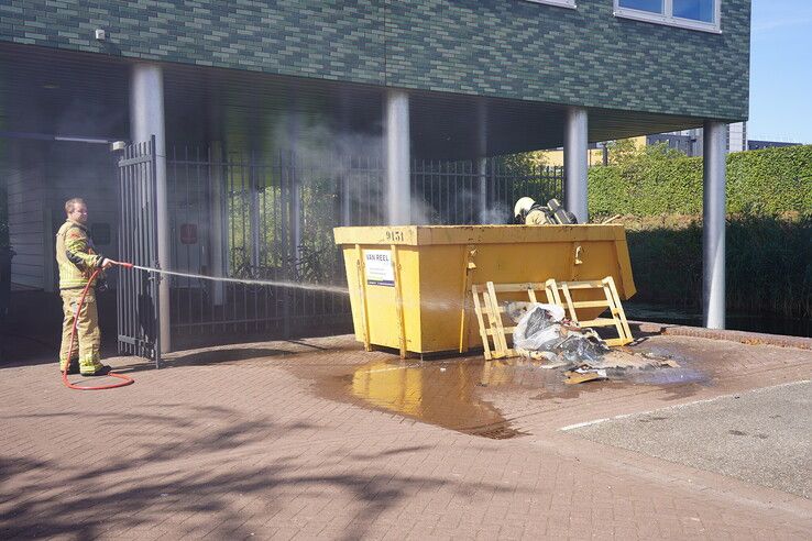 Bouwcontainer met bouwafval in brand